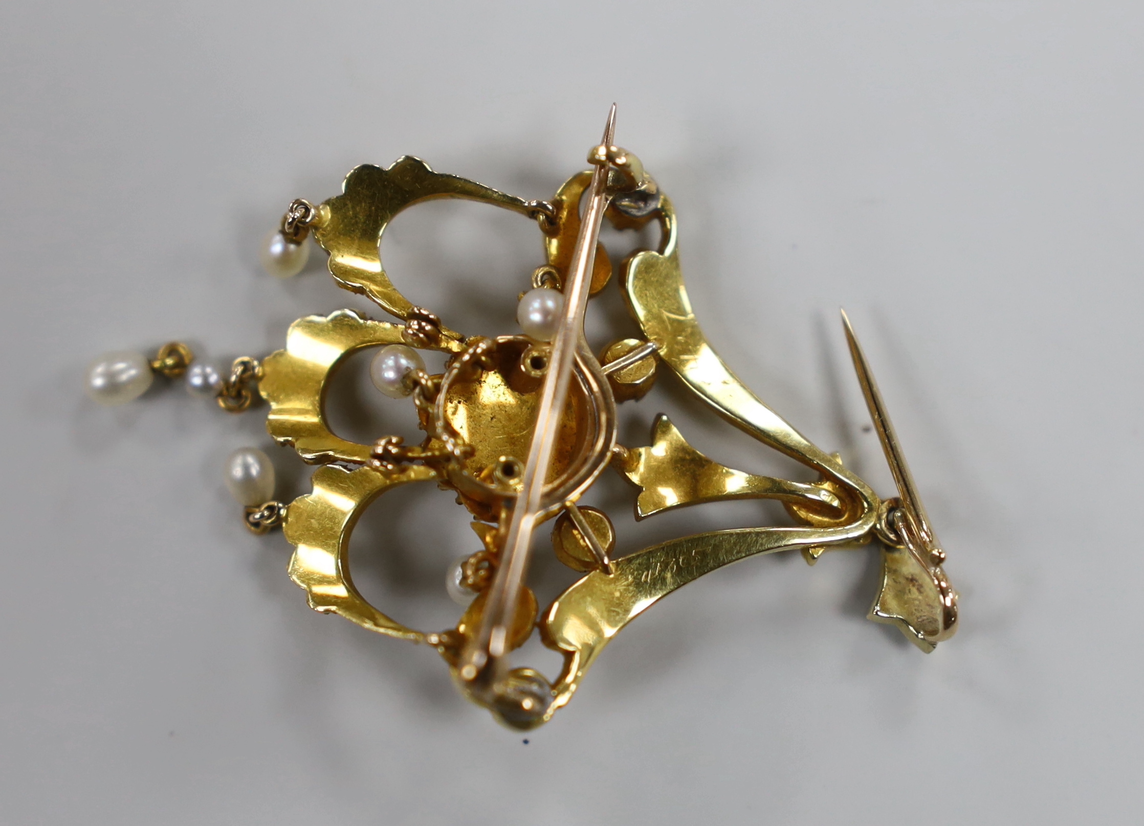 An Edwardian yellow metal and seed pearl set triple drop pendant brooch, 54mm, gross weight 7.5 grams, in original gilt tooled leather fitted case.